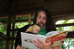 Adam Lehrhaupt reading Warning Do Not Open This Book to a monkey
